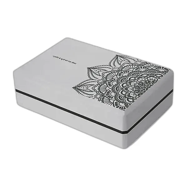Grey EVA foam yoga block with an engraved mandala, three-quarter view