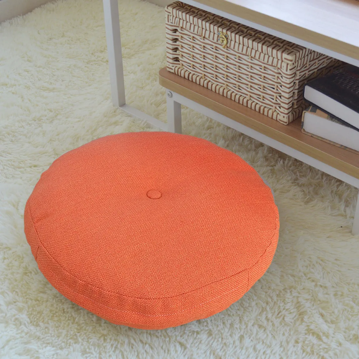 Orange round floor cushion on a soft rug in front of a shelf