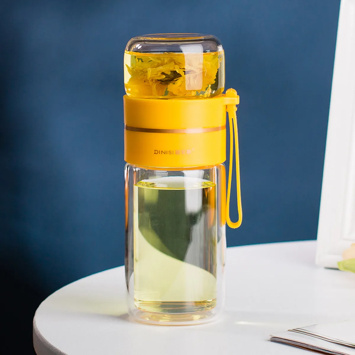 Yellow glass tea bottle filled with an infusion, on a table