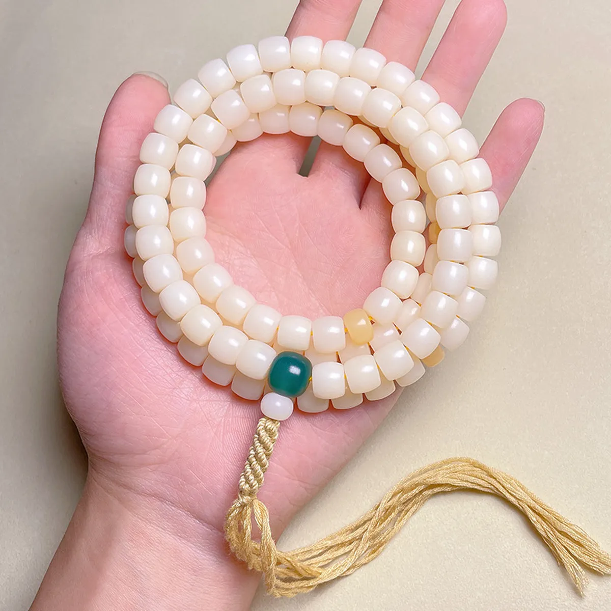 Bodhi root mala coiled in the palm of a hand
