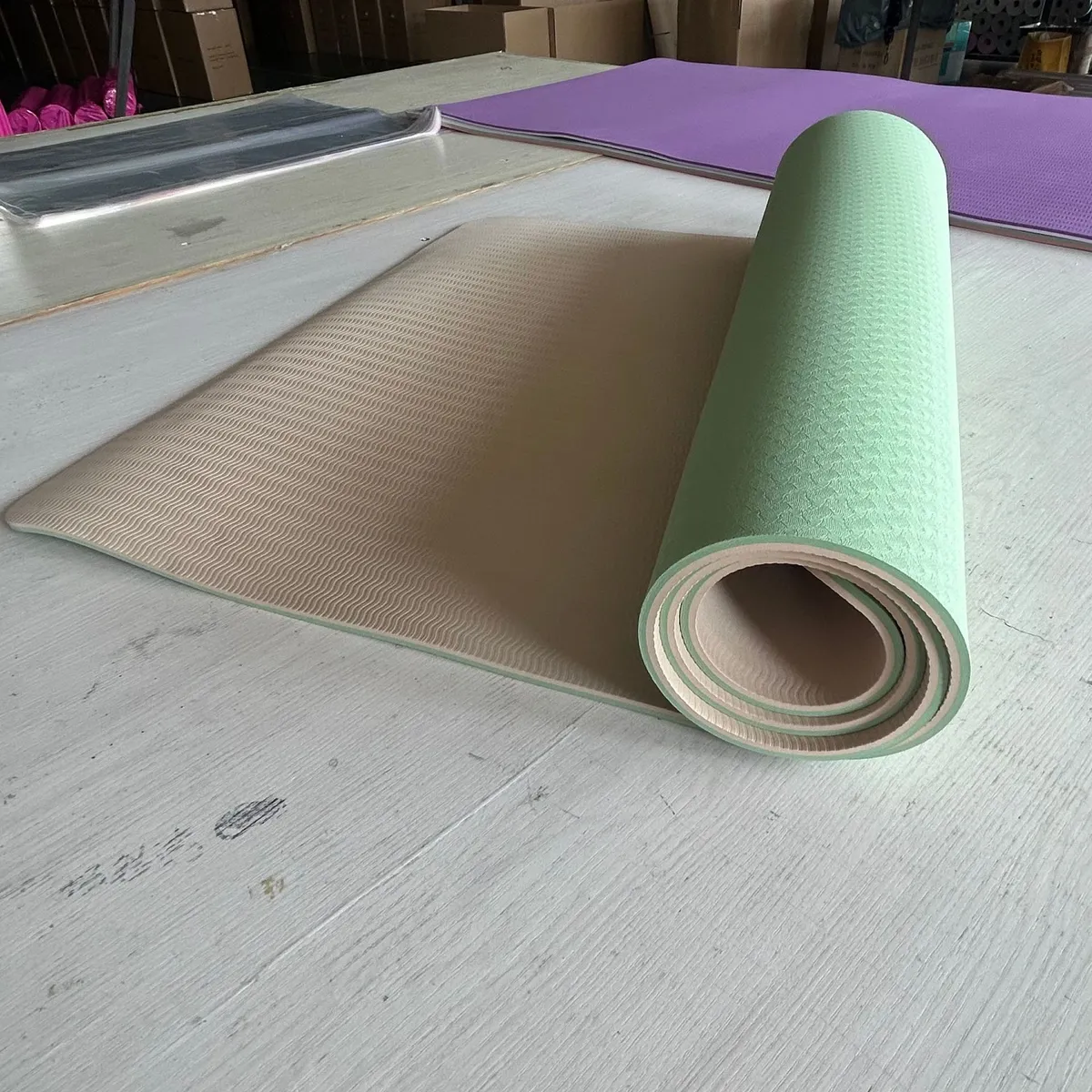 Mint and taupe two-tone yoga mat half unrolled