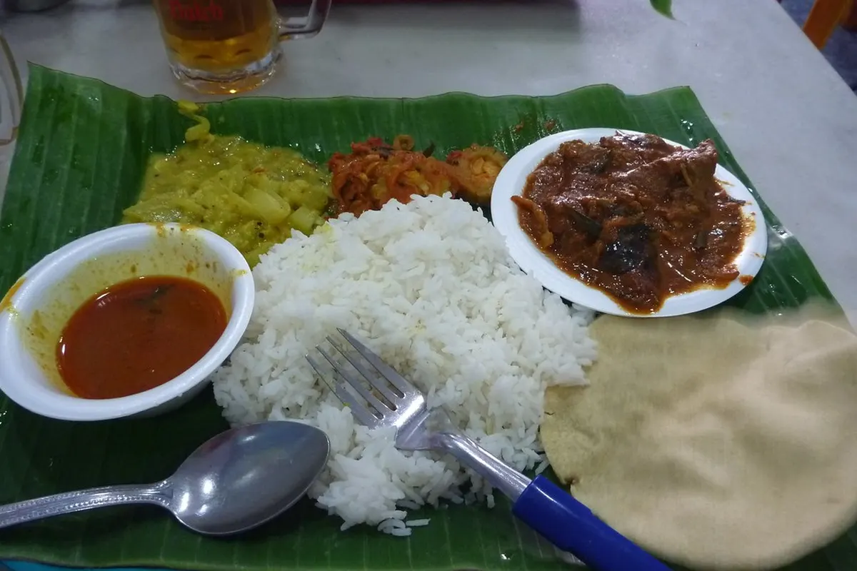 Indian meal served on a banana leaf: rice, sauces and flatbread